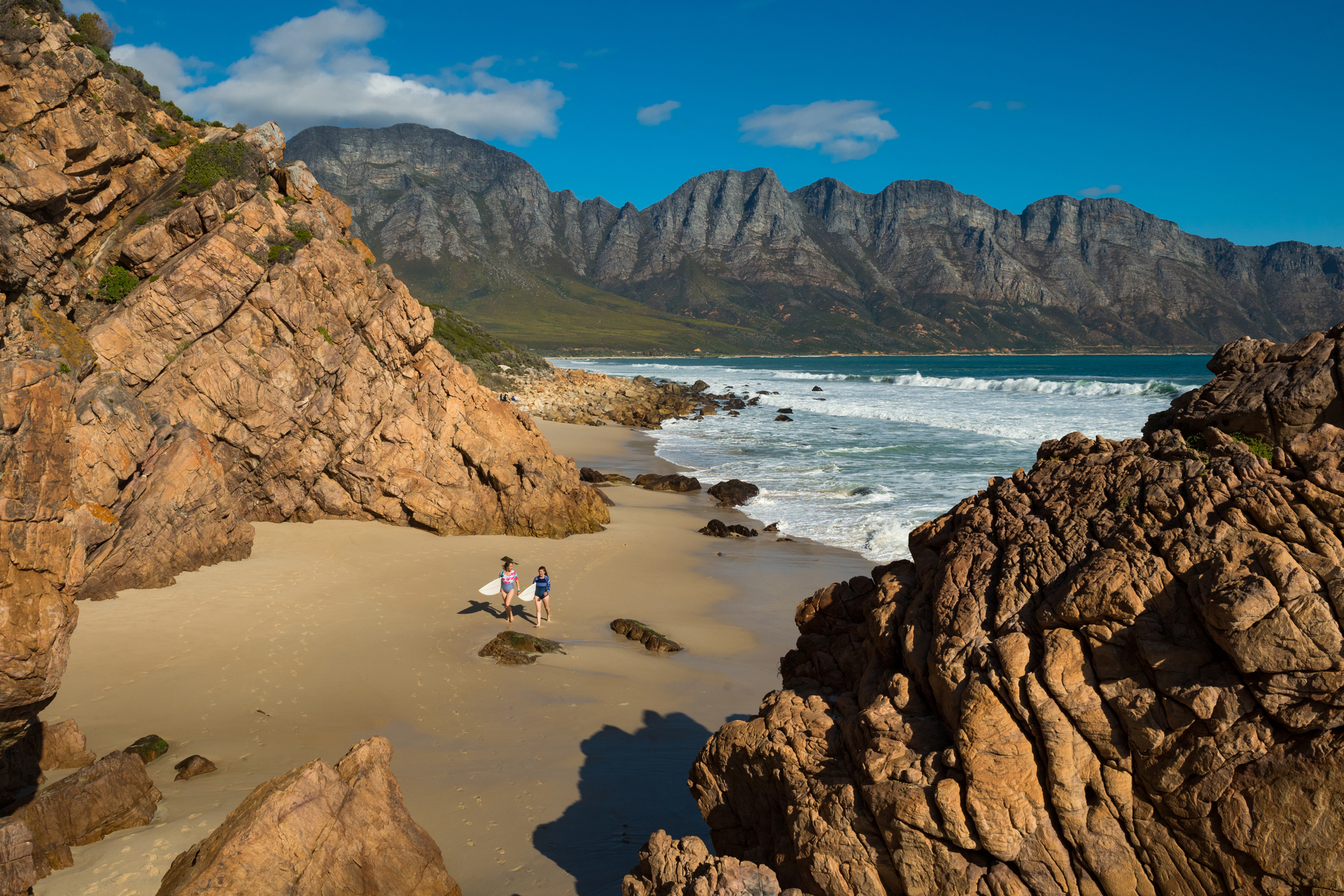 Reisende mit Surfbrettern an einem Strand in Südafrika