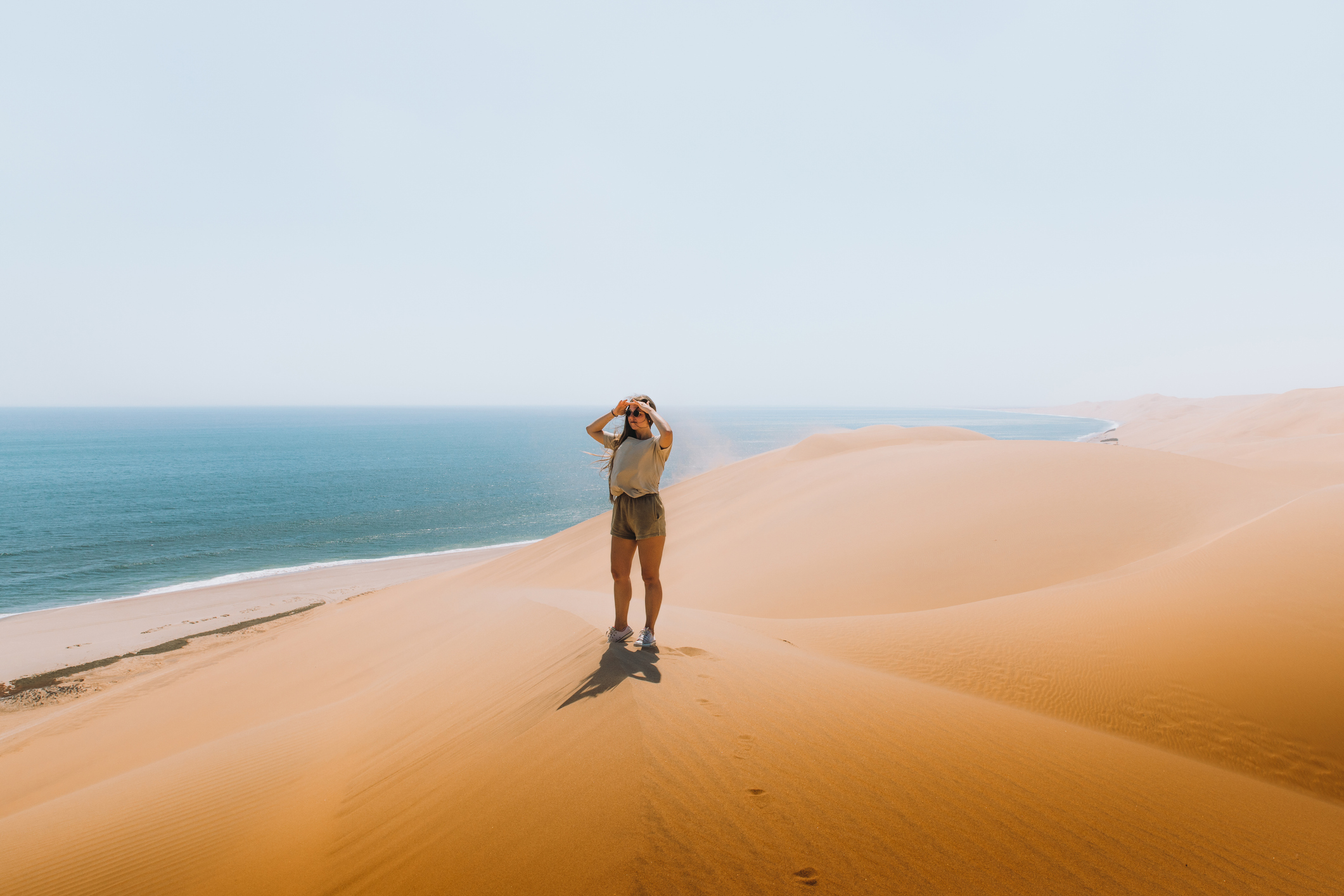 Eine Frau erkundet die wunderschöne Landschaft von Sandwich Harbour in Namibia