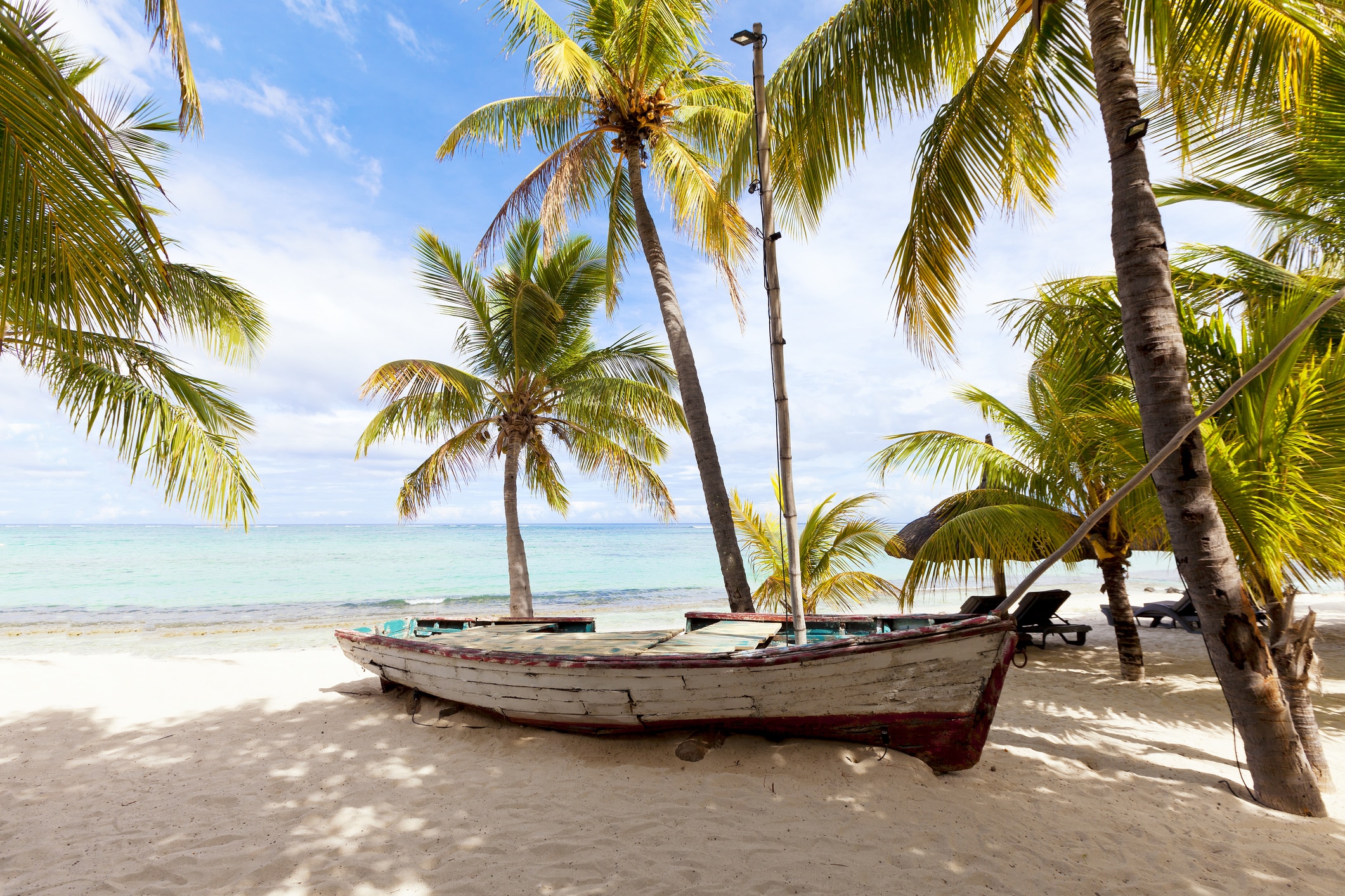 Traditionelles Fischerboot an einem Palmenstrand auf Mauritius
