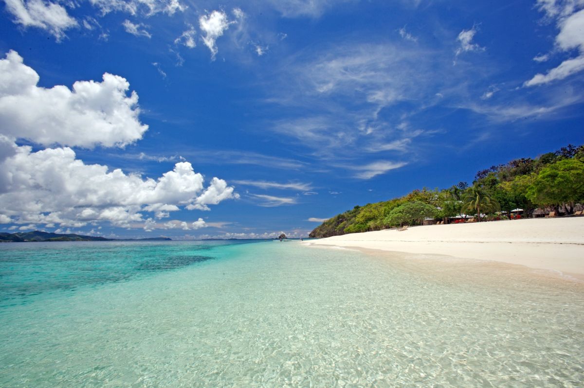Weißer Sandstrand mit türkisblauem Wasser