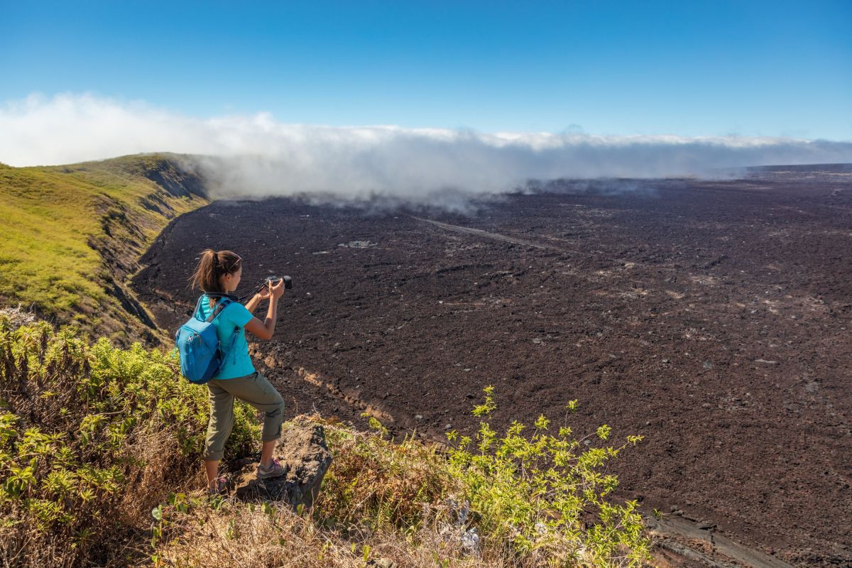 Wanderin auf den Galapagos-Inseln fotografiert die Caldera des Sierra Negra Vulkans