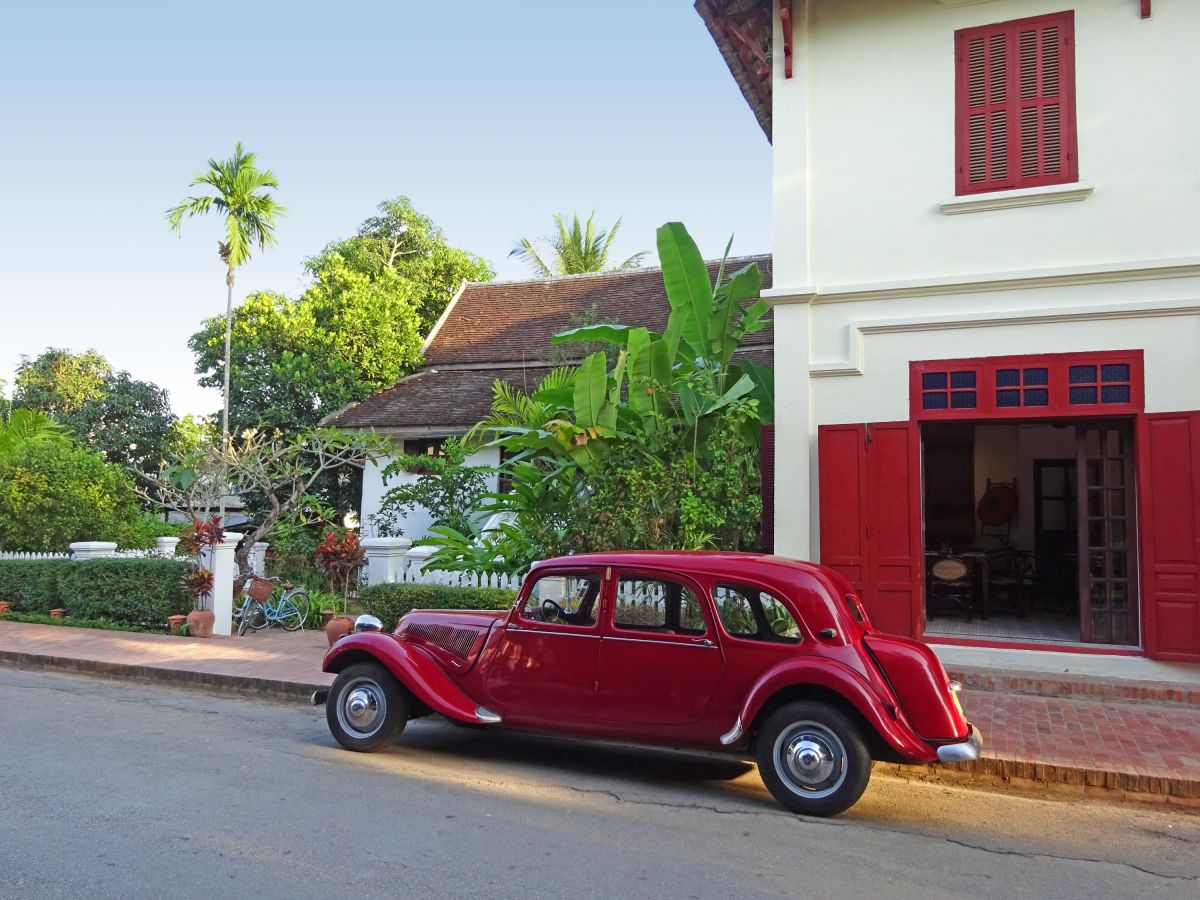 Kolonialcharme in Luang Prabang: Entspannen am Straßenrand mit einem roten Fahrzeug