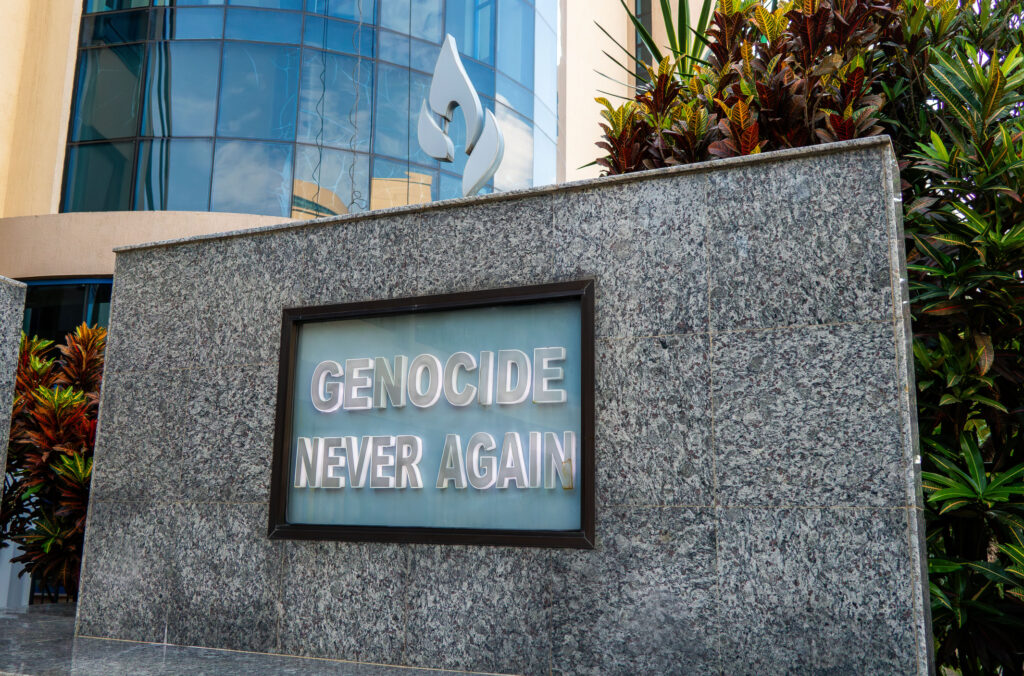 Plakette mit 'Genocide never again' auf Steinwand