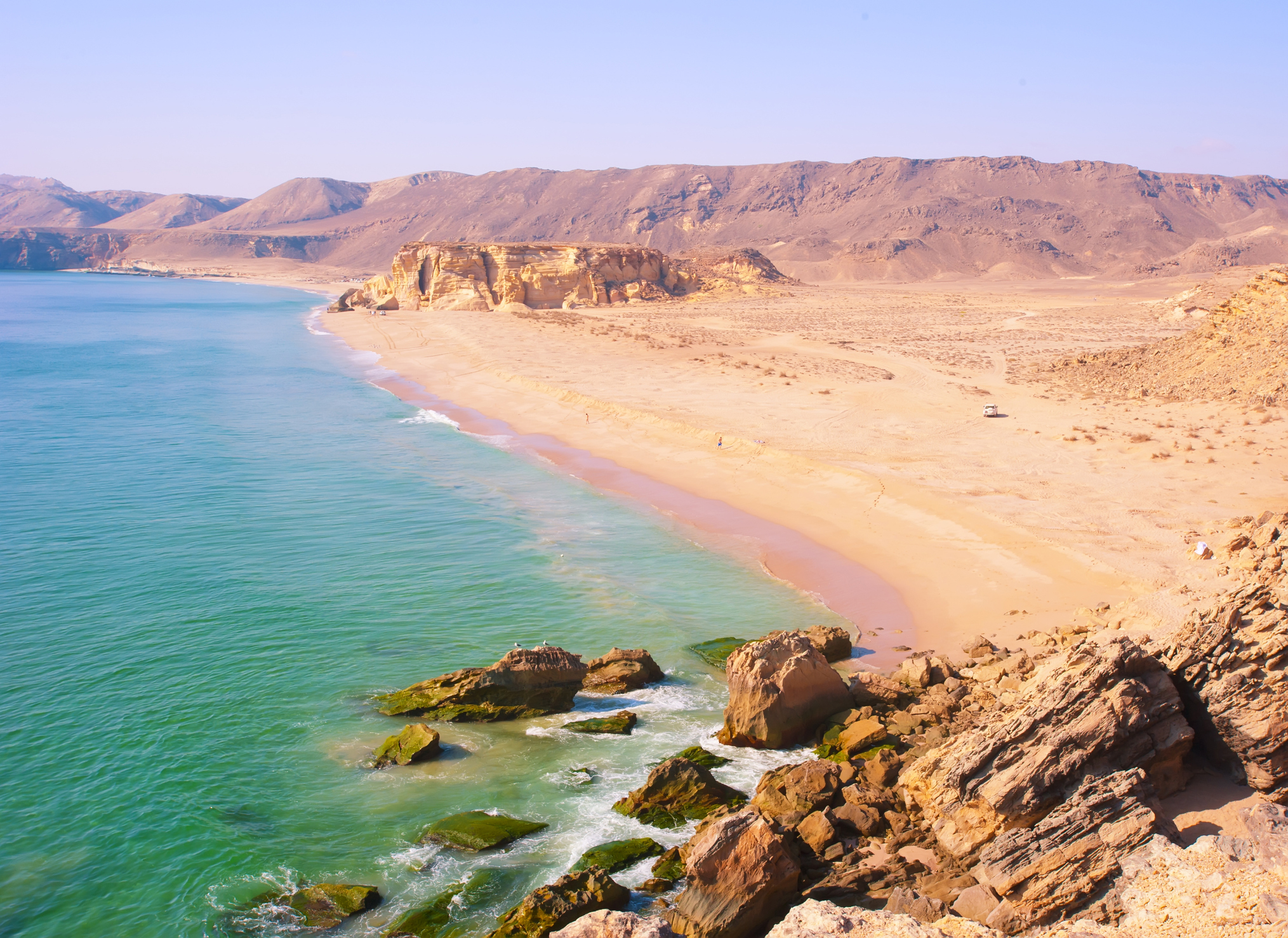 Große Bucht umgeben von Klippen und Wüste Oman