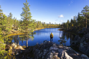Wanderer an einem See mit Tannenbäumen