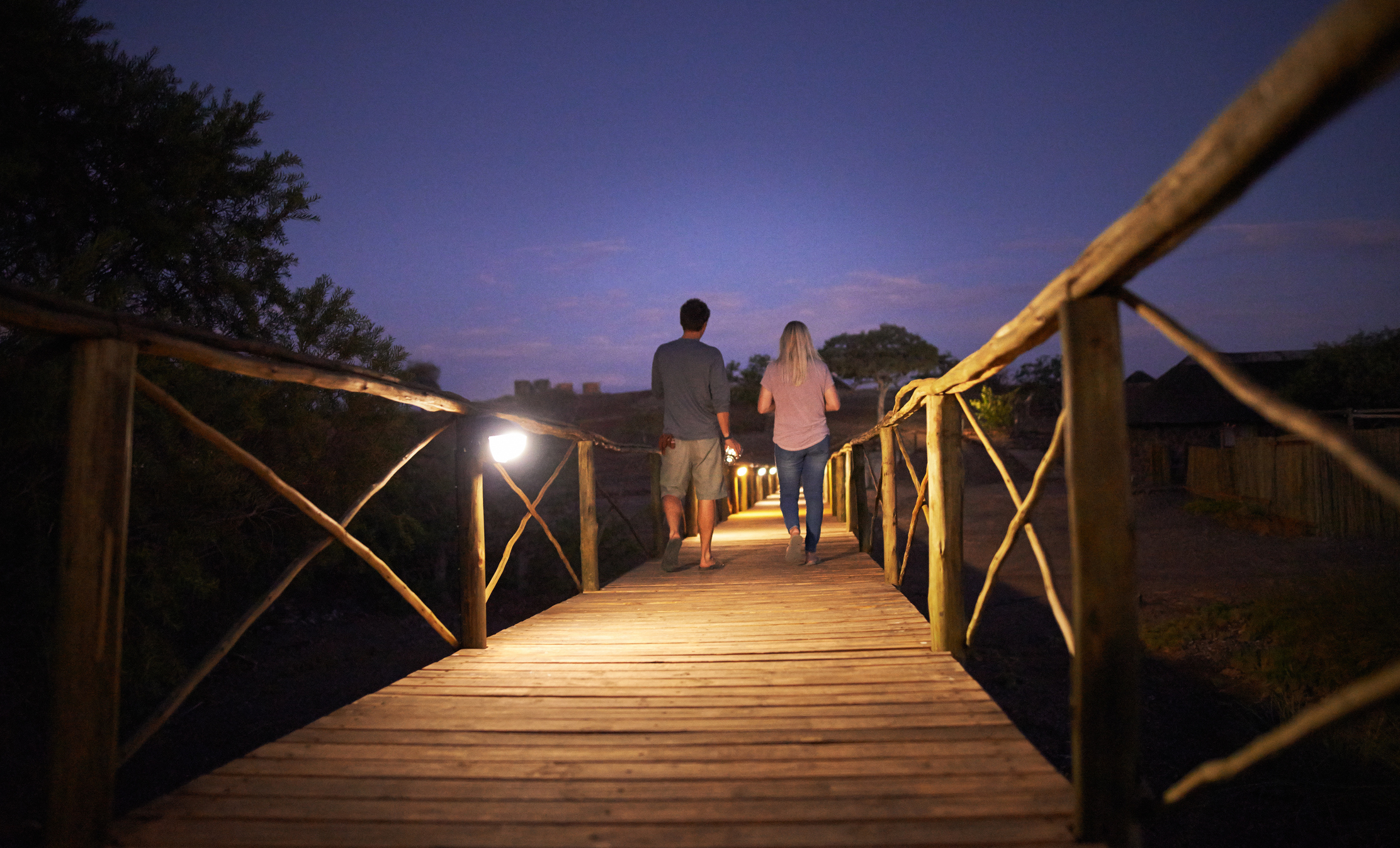 Paar geht auf Steg bei Nachtanbruch