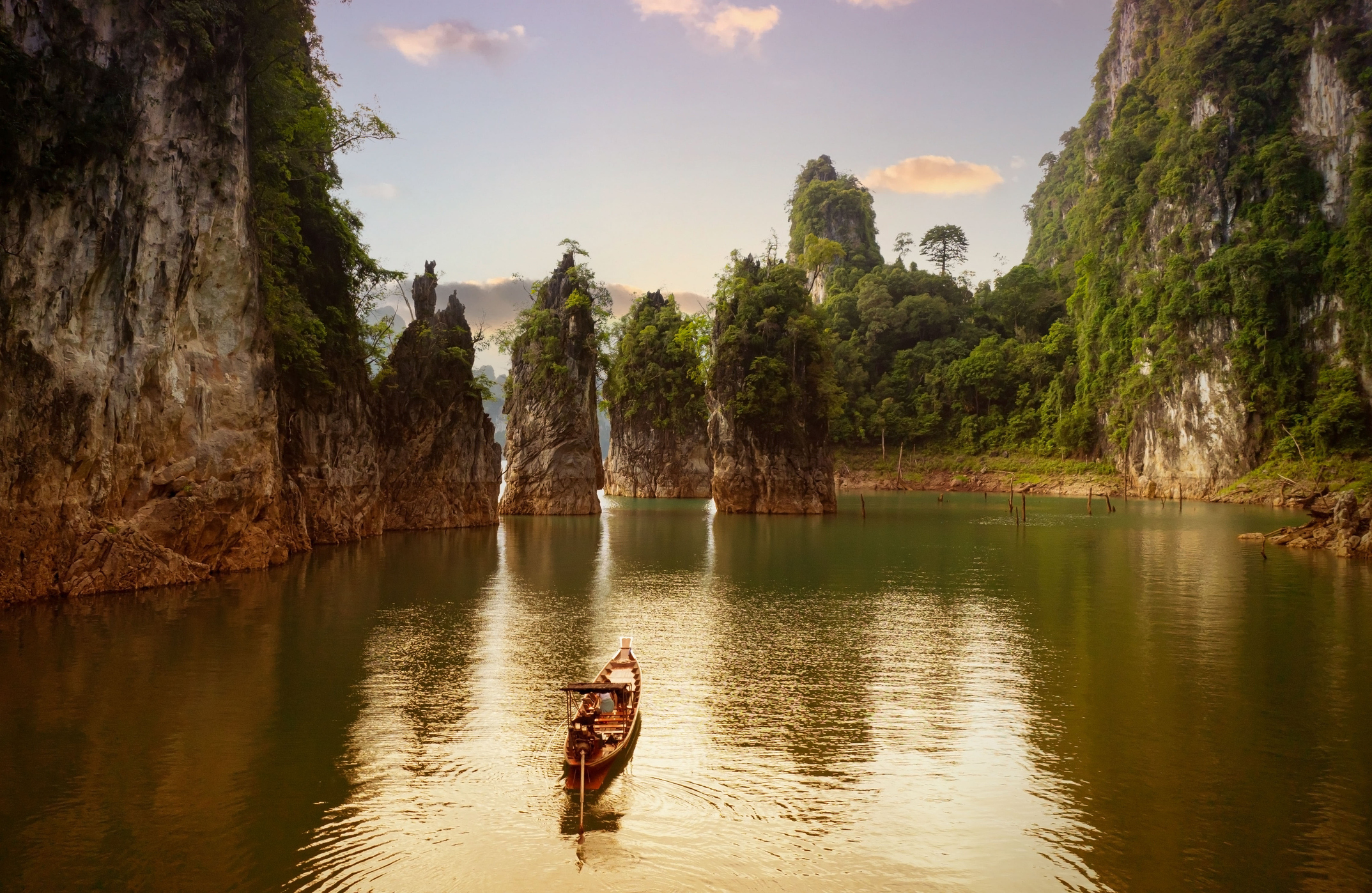 Luftaufnahme des Cheow-Lan-Staudamms mit Boot im Khao-Sok-Nationalpark vor blauem Himmel in Surat Thani, Thailand.