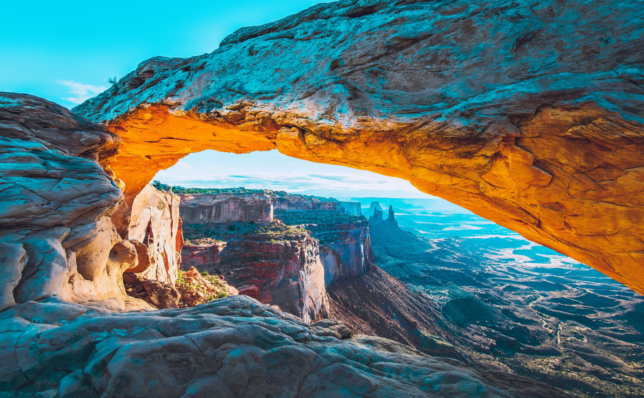 Der Sonnenaufgang am Mesa Arch im Canyonlands National Park lässt den Bogen erstrahlen, Utah, USA.