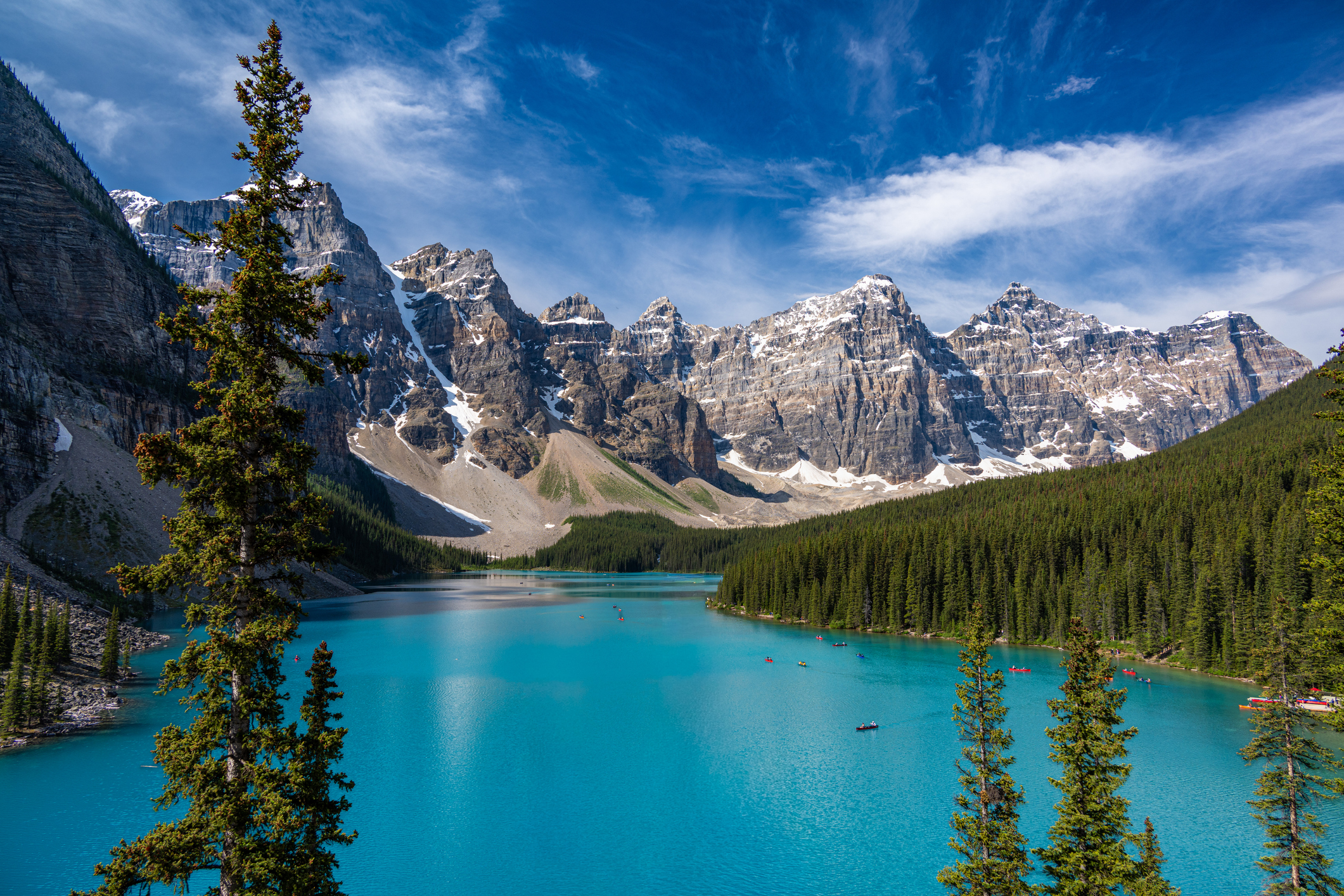 Ein atemberaubender Blick auf den Moraine Lake im Banff-Nationalpark in Alberta, Kanada. Das ikonische türkisfarbene Wasser ist umgeben von den schroffen Gipfeln der kanadischen Rocky Mountains und dichten immergrünen Wäldern.