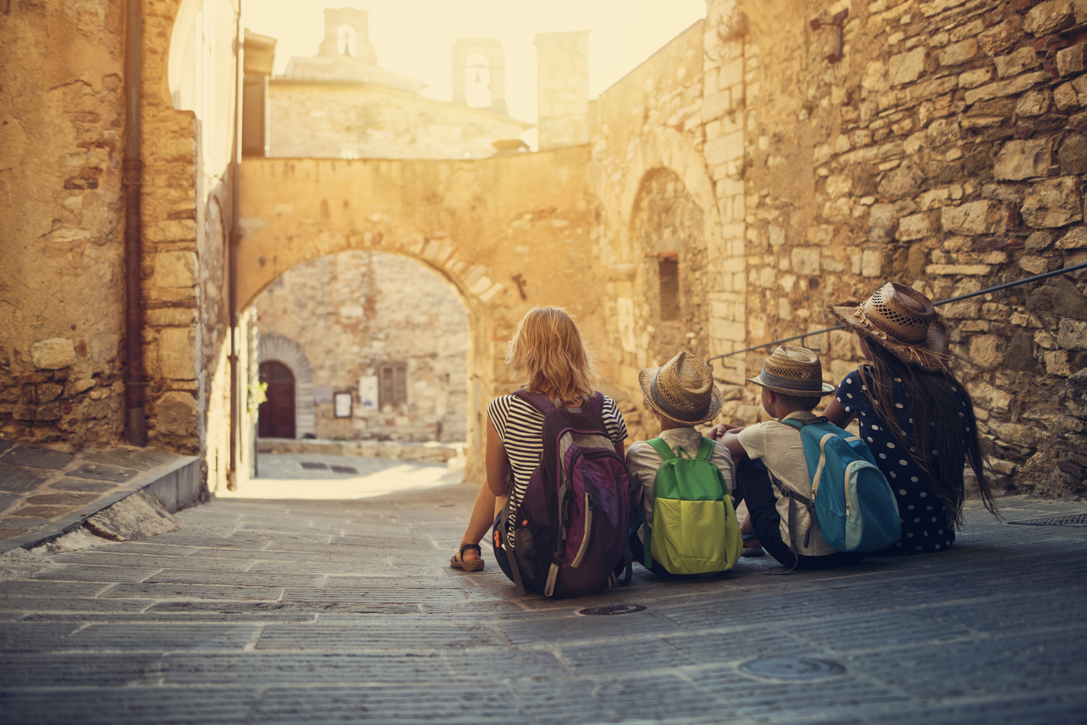Eine Mutter mit ihren Kindern besichtigt alte Ruinen mit Sonnenlicht