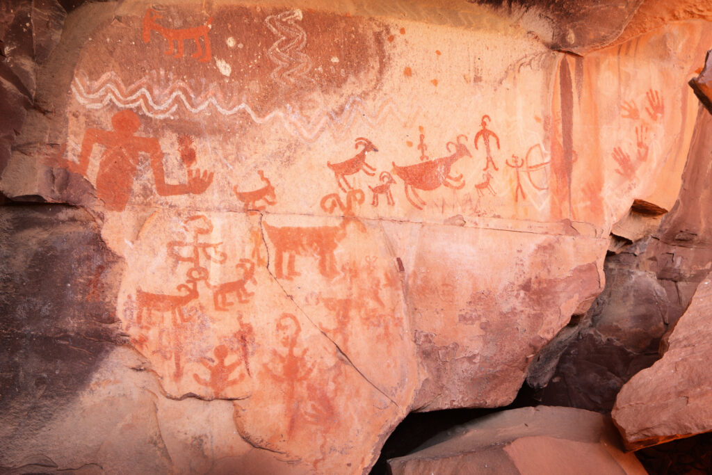 Felsbildkunst in Palatki im Loy Canyon, Arizona. Die meisten Kunstwerke werden den Sinagua zugeschrieben, die das Gebiet zwischen 650 und 1200 n. Chr. besiedelten. Teilweise sind jedoch auch Darstellungen aus anderen Epochen mit den Sinagua-Kunstwerken vermischt und überlagert. Primitivere Ritzzeichnungen datieren bis zu 6000 Jahre alt, während einige wenige Markierungen von Vorfahren der Apachen stammen (bestätigt von Stammesältesten). Piktogramme sind gemalte Bilder, Petroglyphen hingegen sind Ritzzeichnungen, die durch Abschleifen des Gesteins mit der Kante eines anderen Steins entstanden sind. Die Piktogramme in Palatki sind typischerweise in Weiß, Rot und Schwarz oder aus Kaolin, Hämatit und Holzkohle gehalten. Archäologen vermuten, dass viele der Kunstwerke in Palatki mit den Traumbildern der alten Schamanen in Verbindung stehen. Die Darstellungen spiegeln die typische flache, geschützte Felsnische wider, in der Sinagua-Kunst zu finden ist, mit zahlreichen Tierdarstellungen und Hinweisen auf den Lebensweg auf der Erde. Yavapai County, Arizona, 2013.