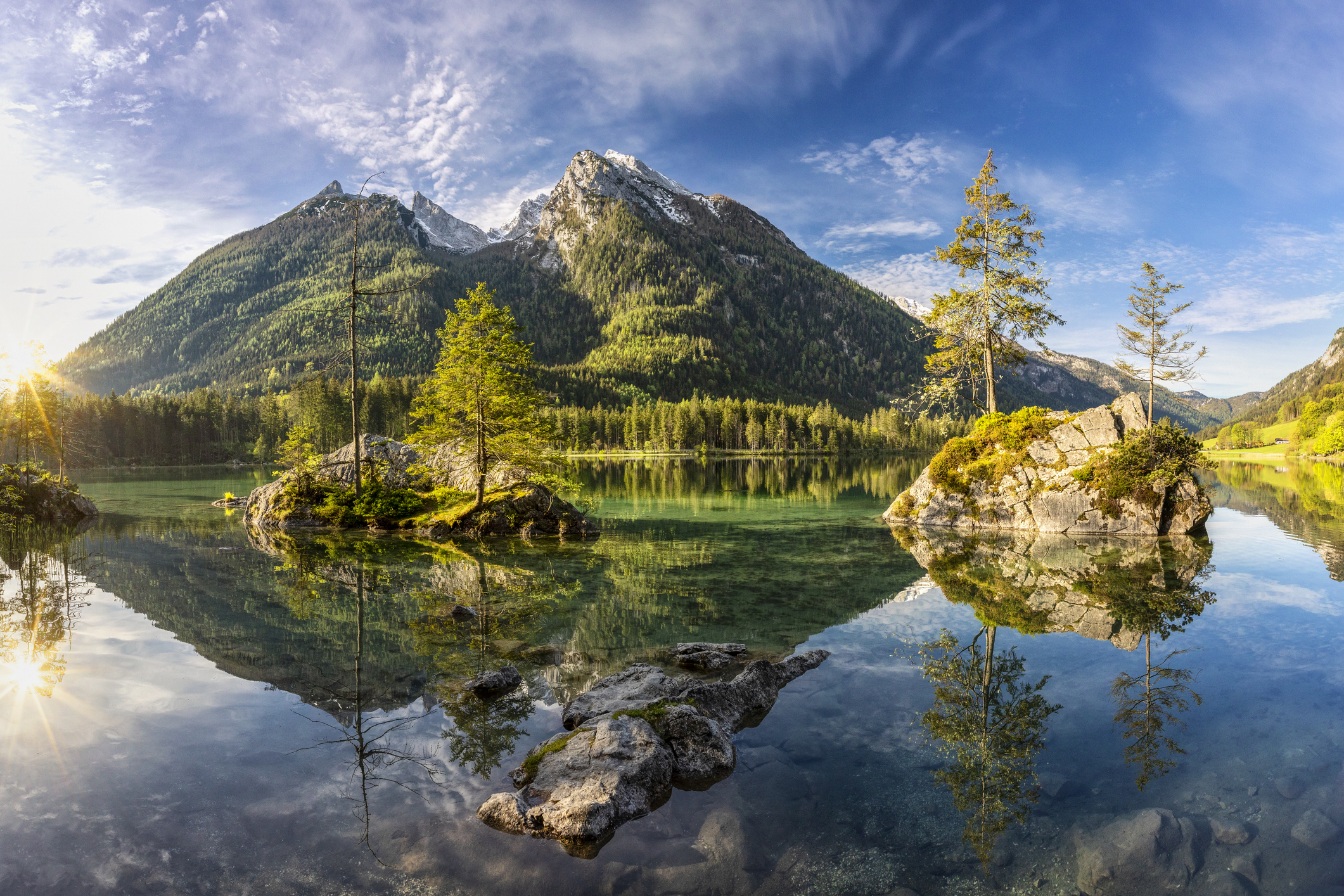 Großer See spiegelt Berge, Bäume und Himmel