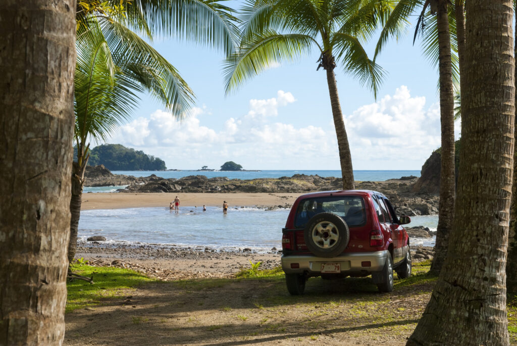 Fahrzeug und Familie am tropischen Strand