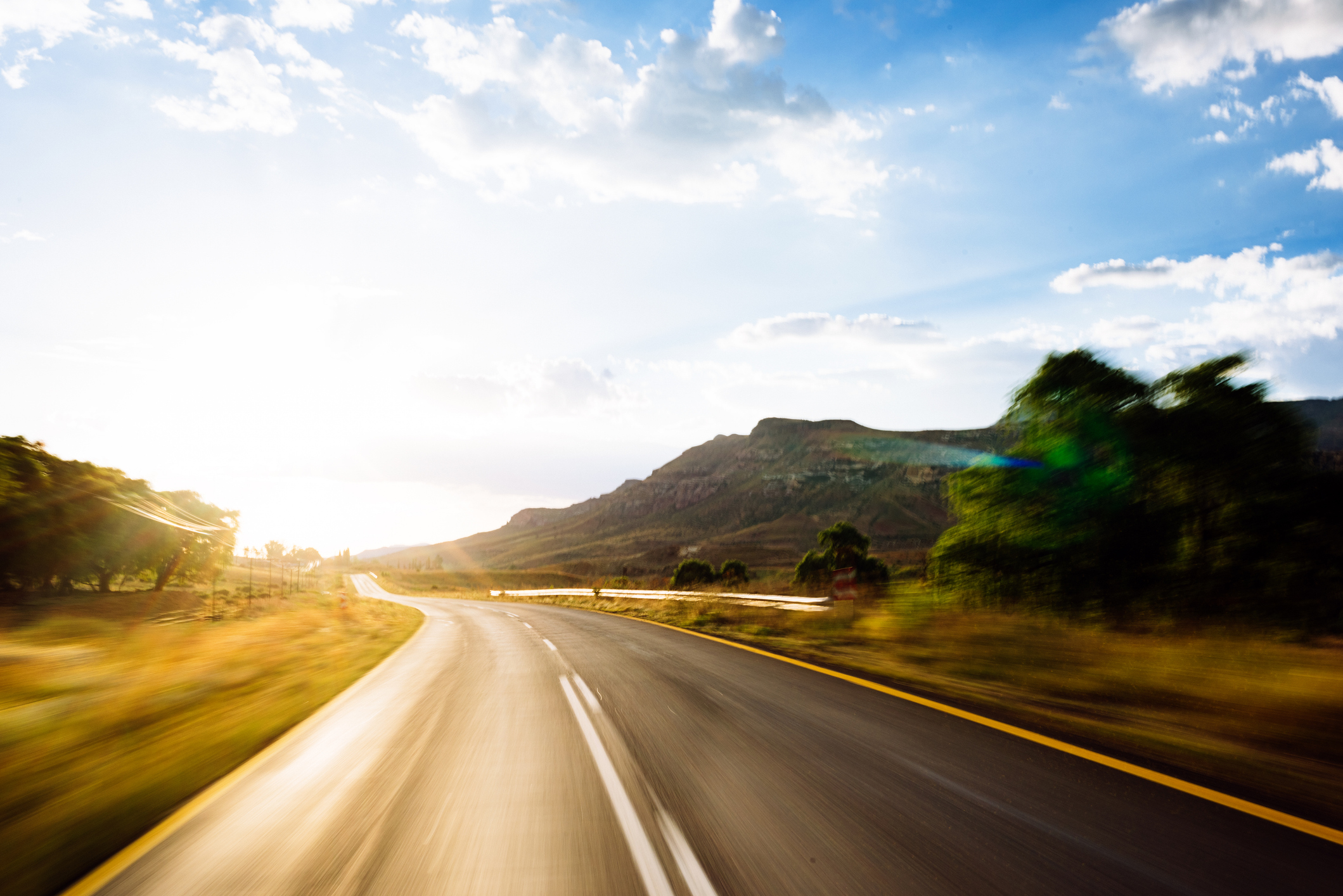 Eine lange, endlose asphaltierte Straße auf dem Land bei Sonnenuntergang in Südafrika