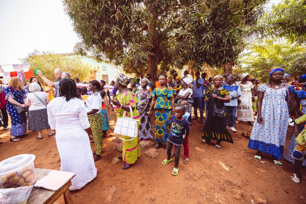 Eine Gruppe von Menschen in traditioneller afrikanischer Kleidung vor einer Kirche in Afrika