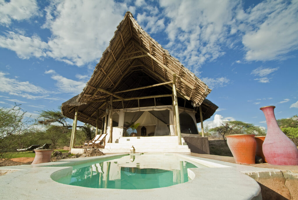 „Weitwinkelaufnahme eines kleinen Pools vor dem Hintergrund eines Safari-Lodge-Zimmers. Samburu, Kenia“
