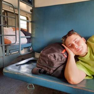 Junge Frau schläft auf einem Sitz im Zug