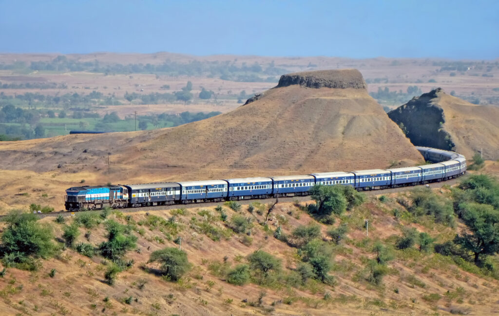 Ein Express-Personenzug durchfährt einen riesigen Einschnitt in Adarki, Maharashtra, Indien.