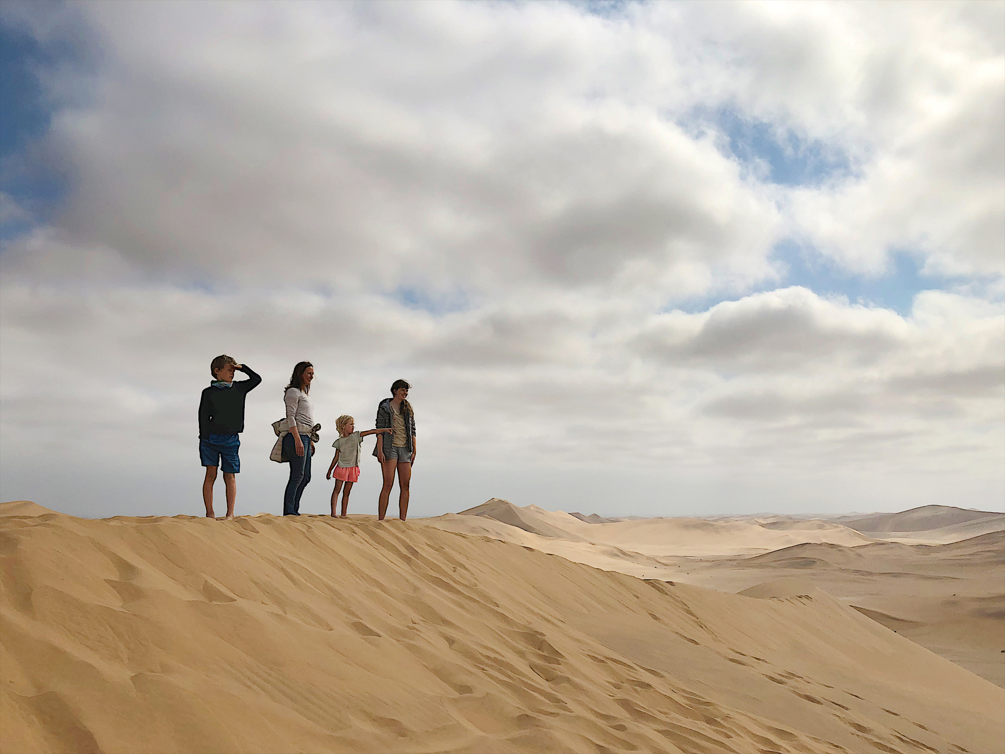 Mutter mit 3 Kindern auf einer Sanddüne in Namibia