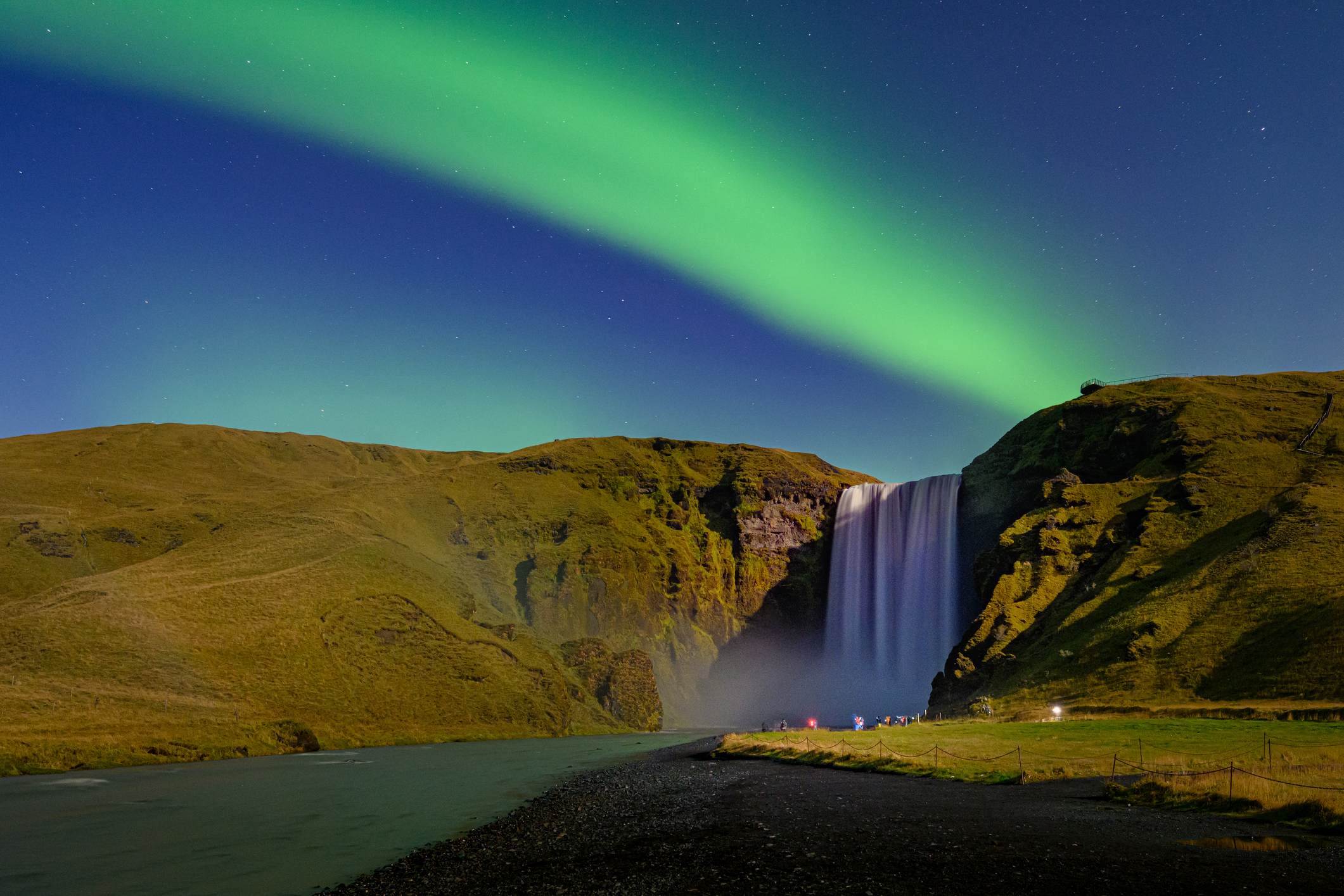 Nordlichter am Skogafoss-Wasserfall in Südisland mit Mondregenbogen.