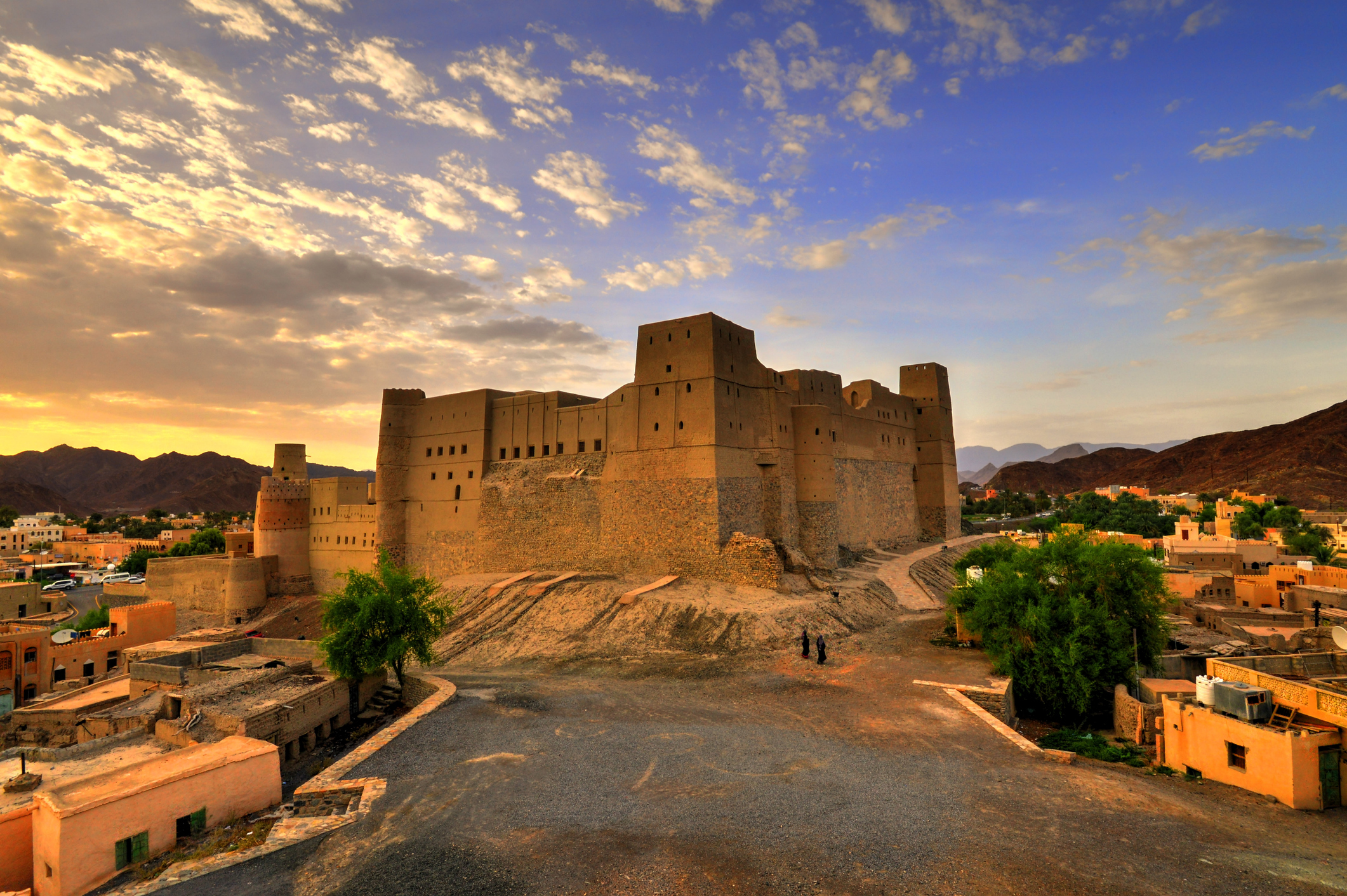 Festung im Oman in glebes Licht getaucht und Wolkenspiel am Himmer