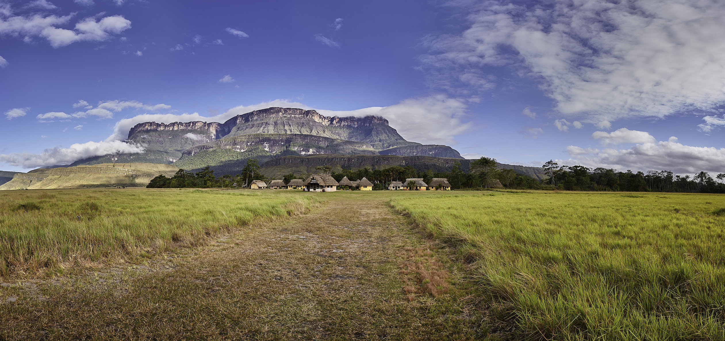 Lodge vor einem Berg mit Wolkenhimmel