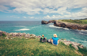 Vater und Sohn sitzen am felsigen Meeresufer