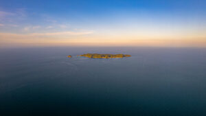 Eine Drohnenaufnahme einer Insel bei Sonnenuntergang. Die Insel ist als Pulau Kapas bekannt.