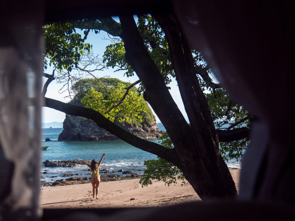 Aussicht vom Zelt: Junge Frau entspannt sich am Strand in Costa Rica