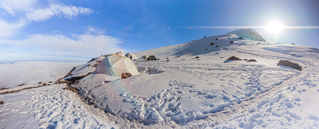 Zeltlager am Chimborazo-Vulkan mit dem Cayambe-Vulkan im Hintergrund