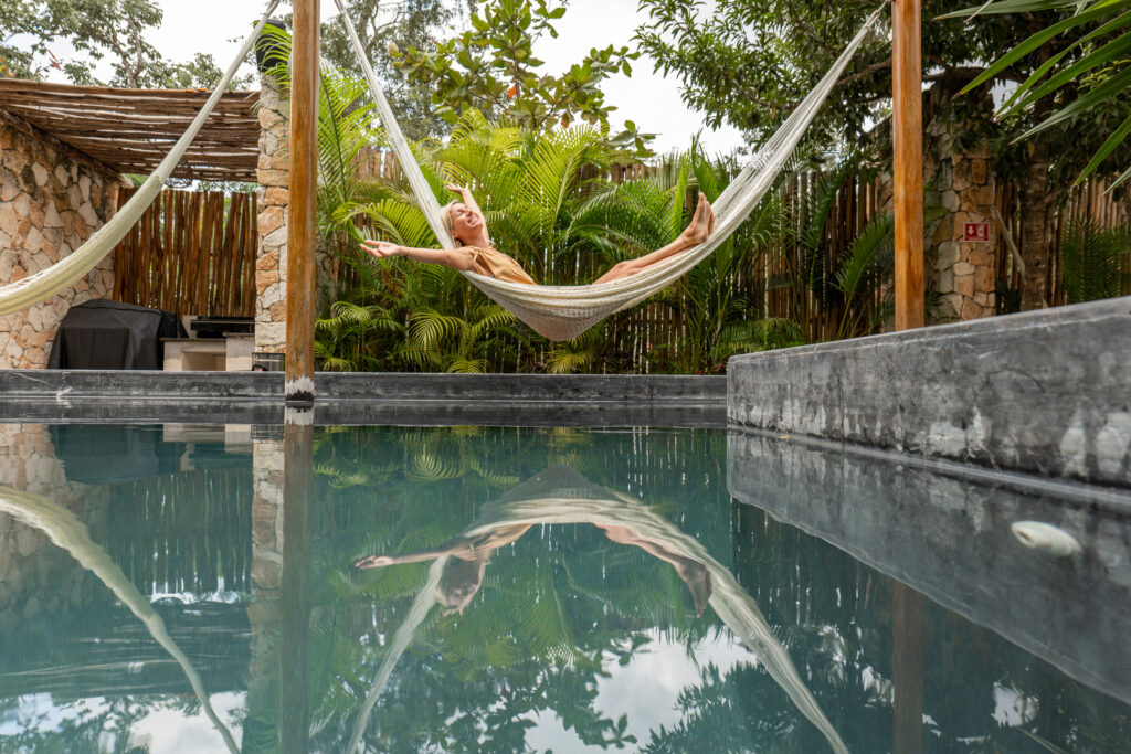 Frau entspannt in einer Hängematte am Pool in einer Lodge in Yucatan