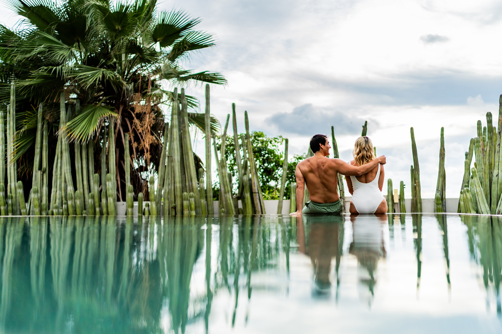 Ein Paar unterhielt sich umarmend am Natur-Pool eines Hotels.