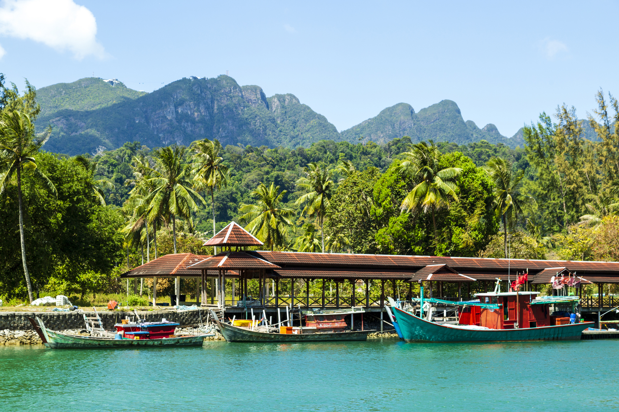 Malaysische Boote im Wasser vor der hügeligen Landschaft Malaysias