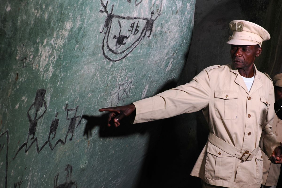 In den Höhlen von Nzau Evua, Angola zeigt ein Führer Wandmalereien im Fels