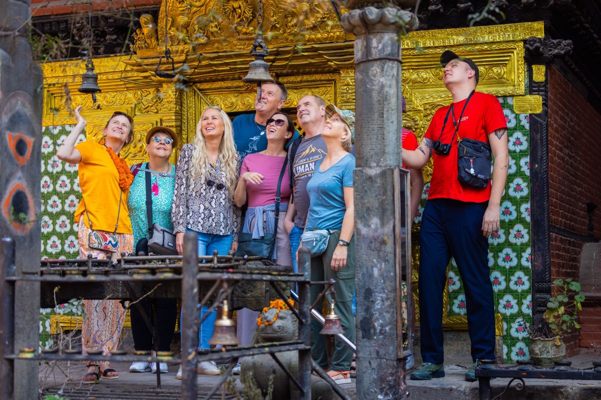 Reisende vor einem goldenen Tempelportal in Bhaktapur, Nepal