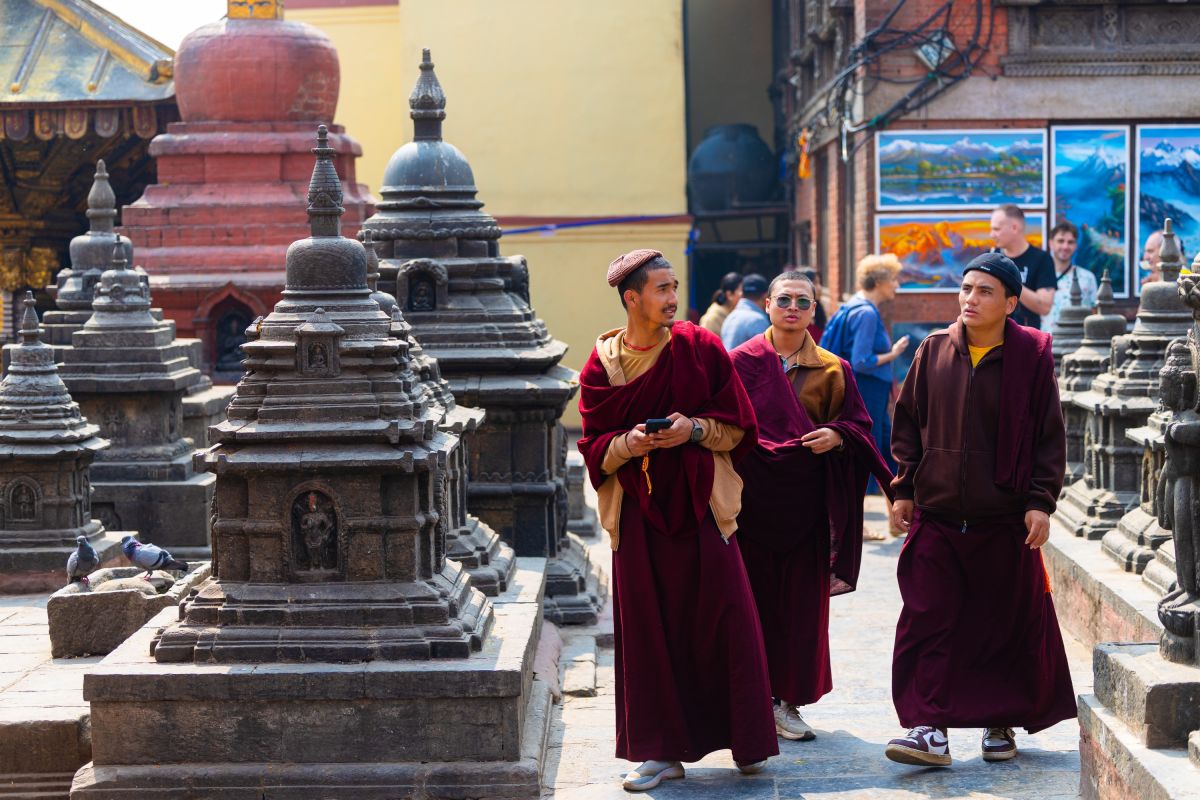 Buddhistische Mönche zwischen kleinen Stupas am Swayambhunath-Tempel in Nepal