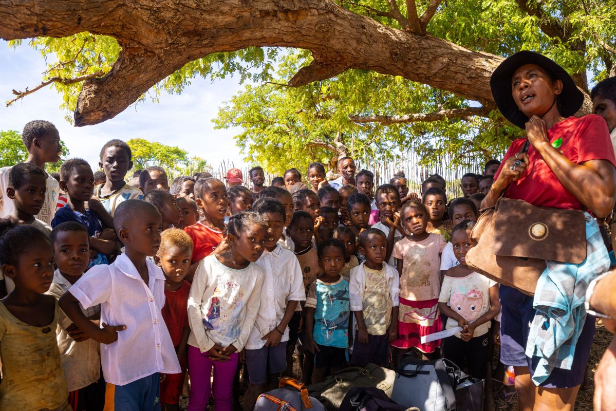 Lebendige Dorfkinder in Madagaskar unter einem schattigen Baum versammelt