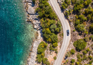 Vertikale Luftaufnahme eines Pick-ups, der auf einer kurvenreichen Straße
