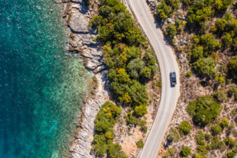 Vertikale Luftaufnahme eines Pick-ups, der auf einer kurvenreichen Straße