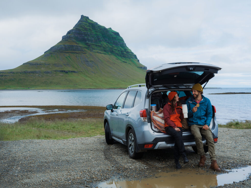 Ein paar in einem Mietwagen in Neuseeland mit szenischer Landschaft