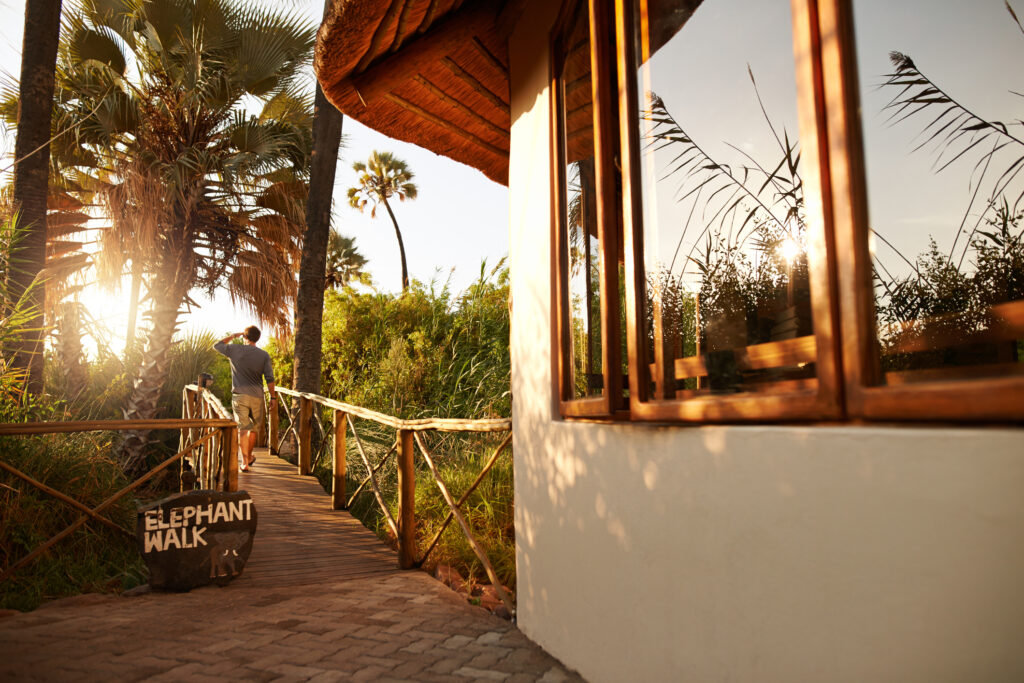 Rückansicht eines unkenntlichen Mannes, der auf einer Brücke in einem Hotel in Südafrika spaziert