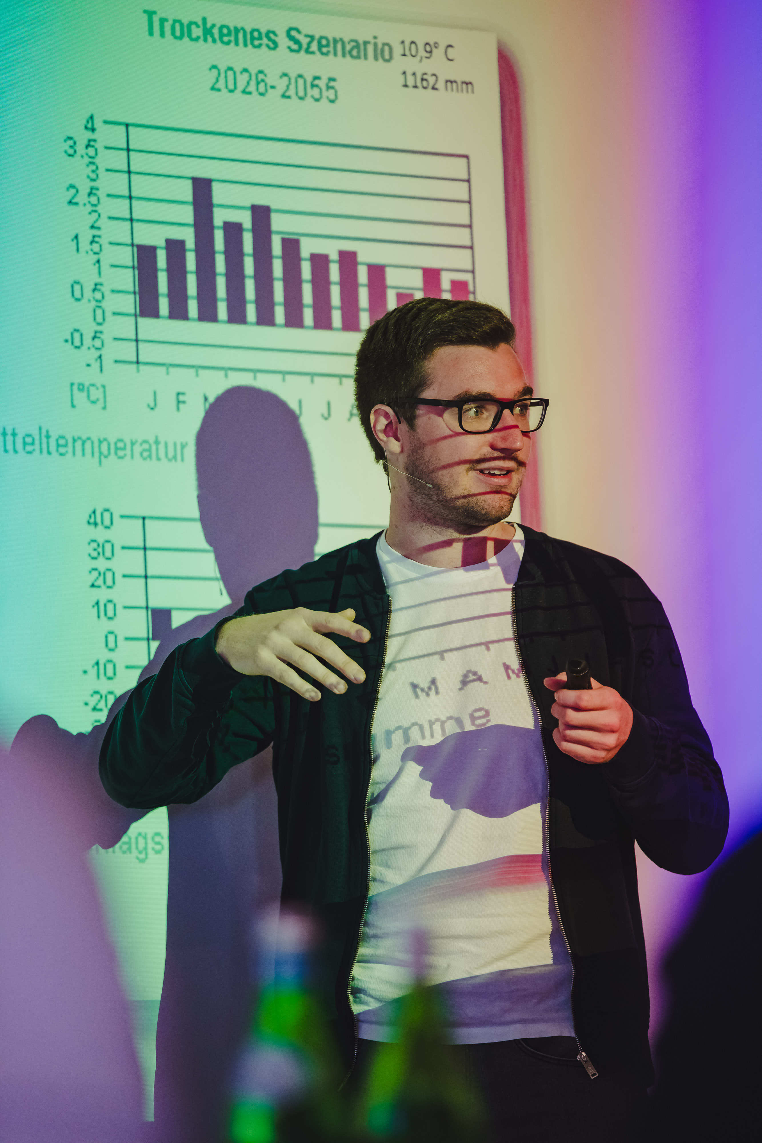 David Nelles bei einem Vortrsag mit Grafik im Hintergrund