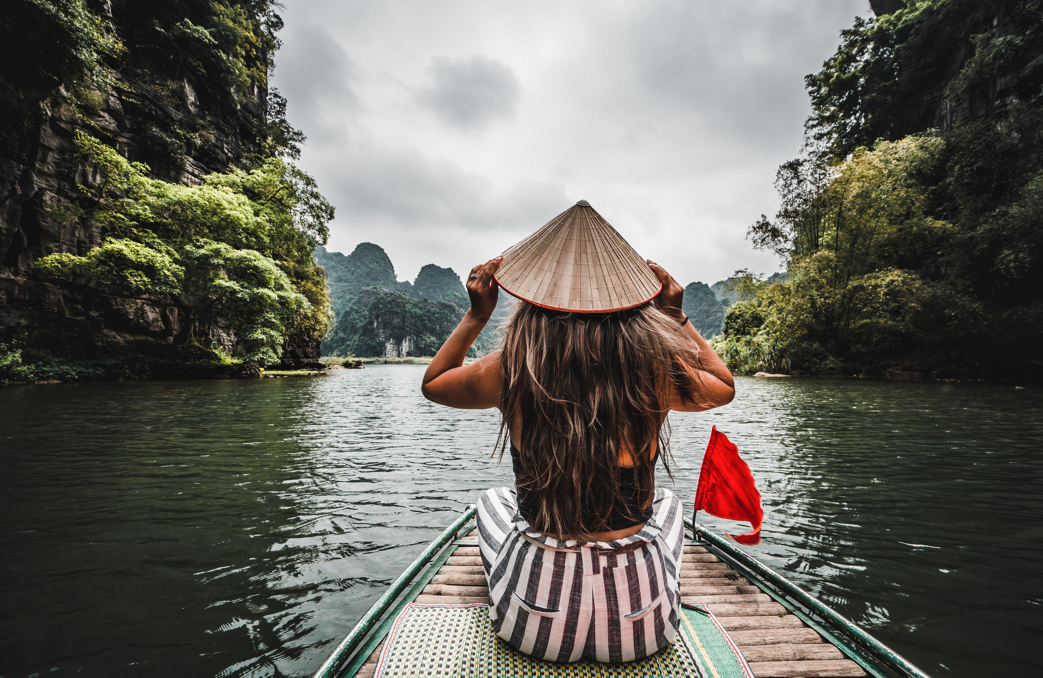 Eine Frau auf einem Flussboot in Ninh Binh. Berge im Norden Vietnams.