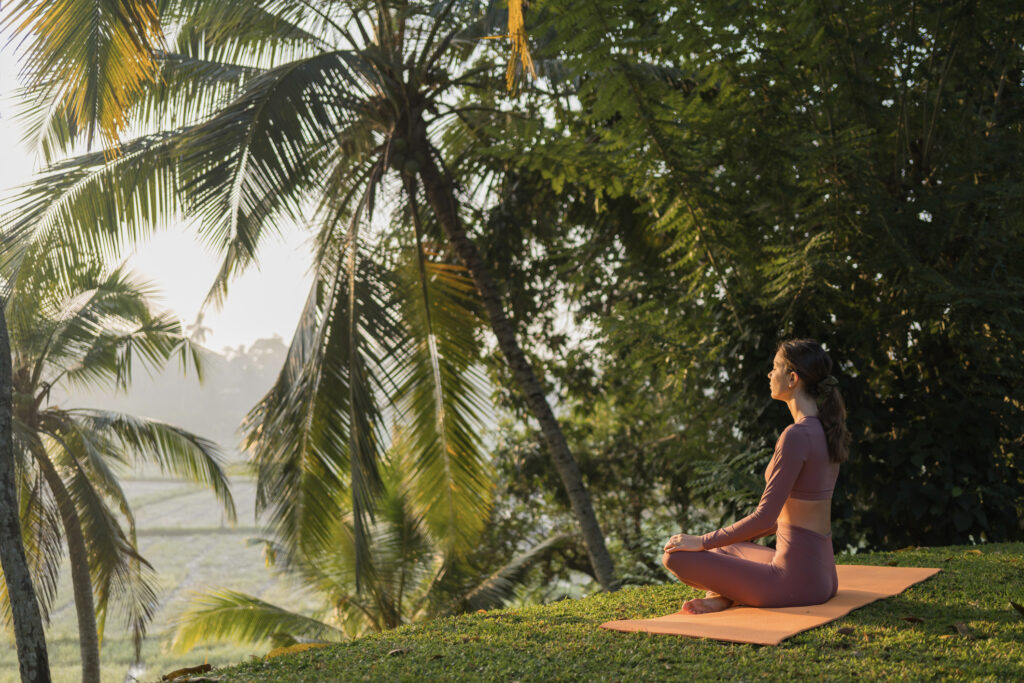 Junge Frau macht Yoga im Freien unter den Palmen von Sri Lanka