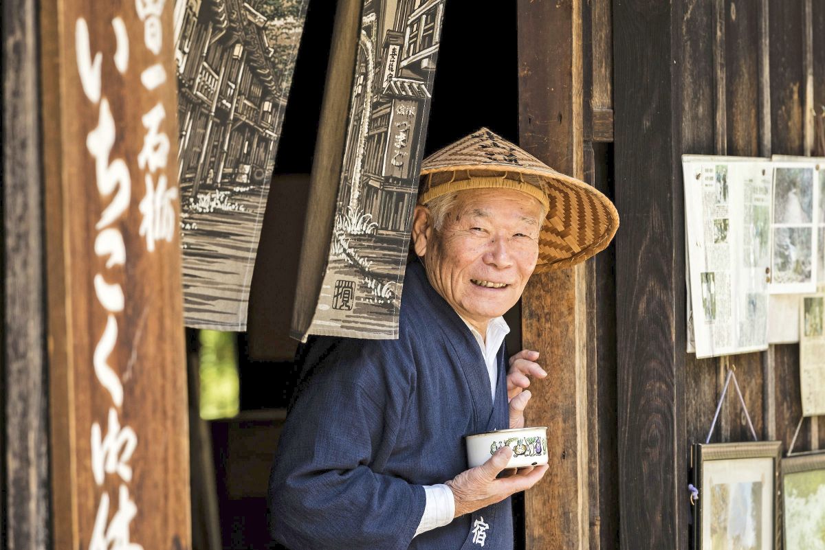 Ein freundlicher Japaner serviert Tee für Wanderer im traditionellen Teehaus Kiso, Japan.