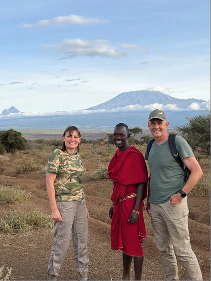 Gäste der Kenia-Reise Löwenwind mit ihrem Safari-Guide vor dem Kilimandscharo