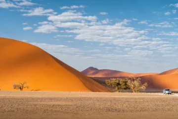 Geländewagen vor den roten Dünen von Sossusvlei auf einer Namibia Selbstfahrerreise