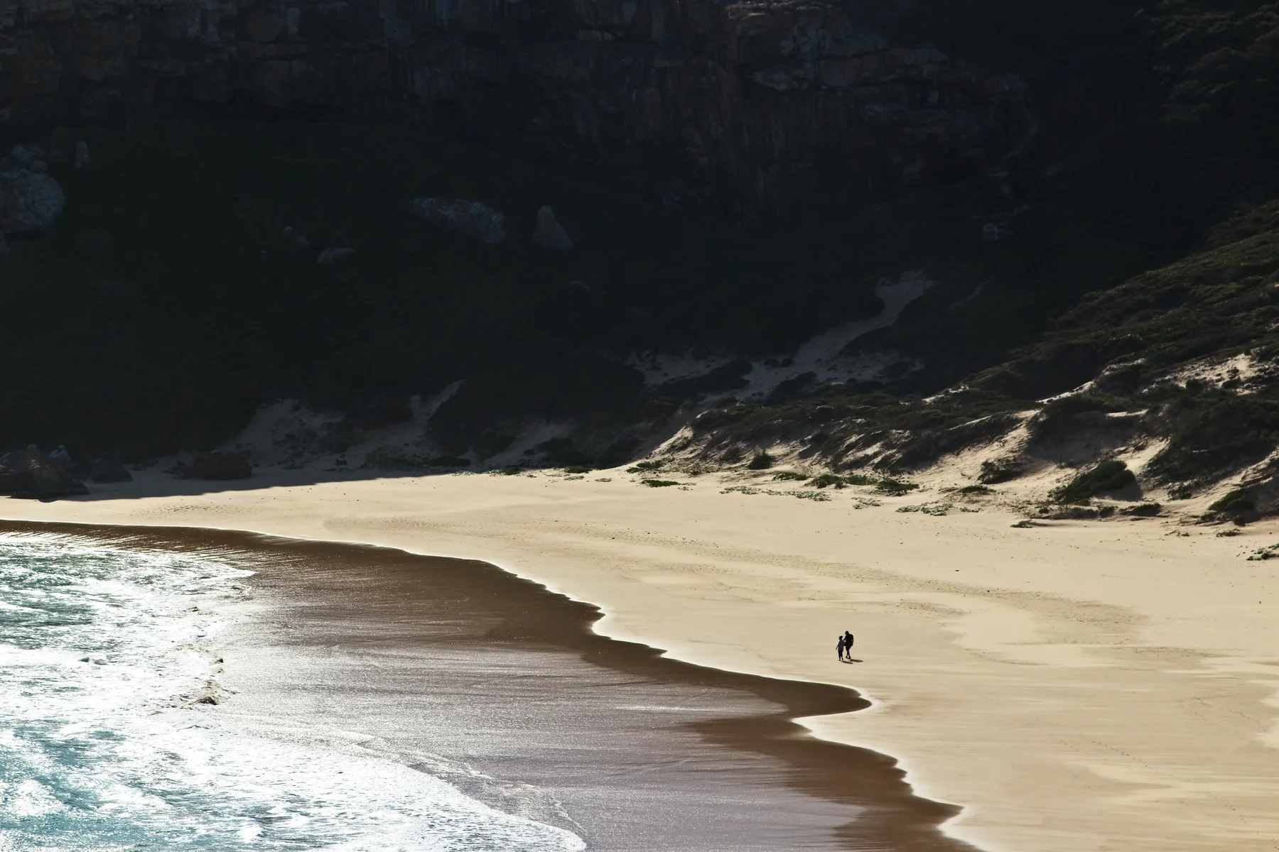 Zwei Reisende spazieren am Strand des Robberg Nature Reserve bei Plettenberg Bay in Südafrika