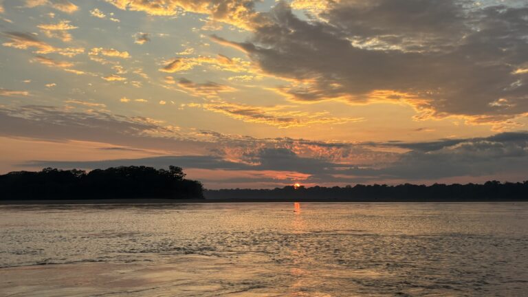 Sonnenuntergang über einem Fluss im Amazonasgebiet von Madre de Dios