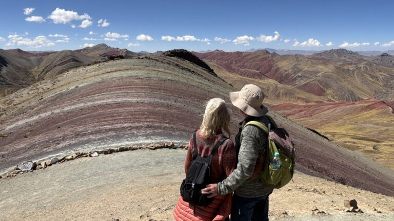 Zwei Gäste vor den farbigen Andenbergen bei Palccoyo in Peru